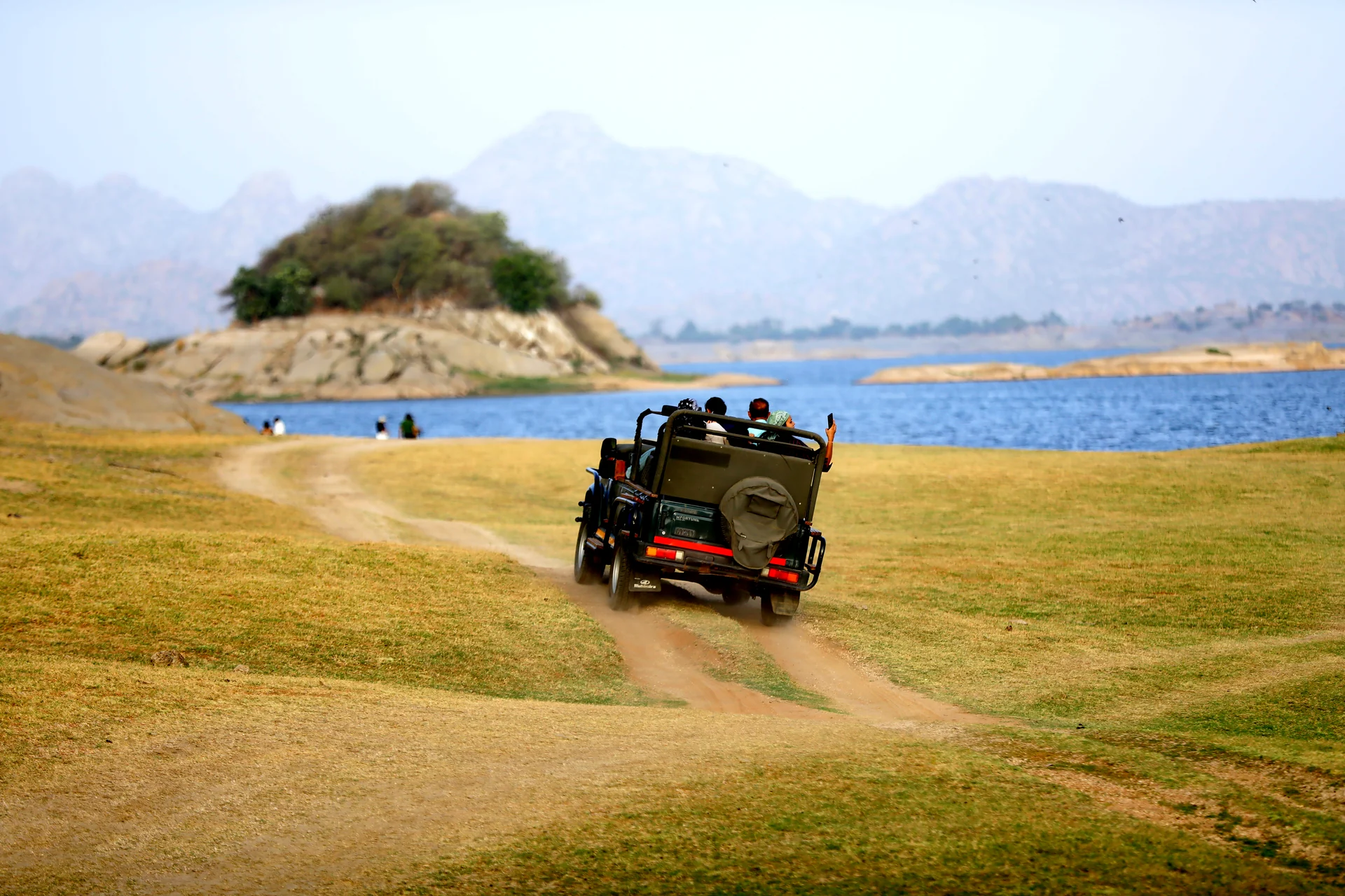 Open jeep travelling along a lakeside trail during a Jawai safari