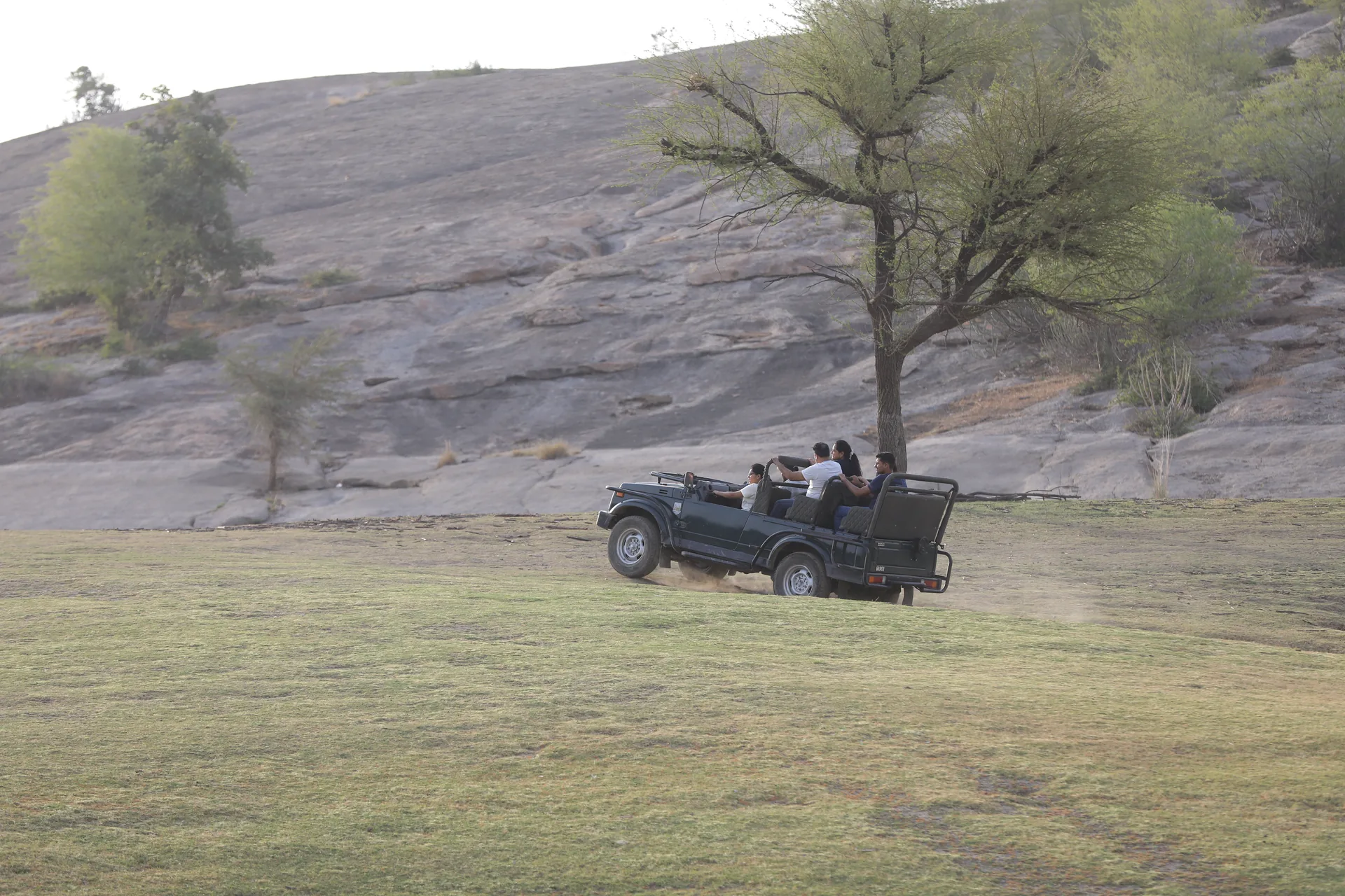 Open safari jeep below Jawai’s granite hills