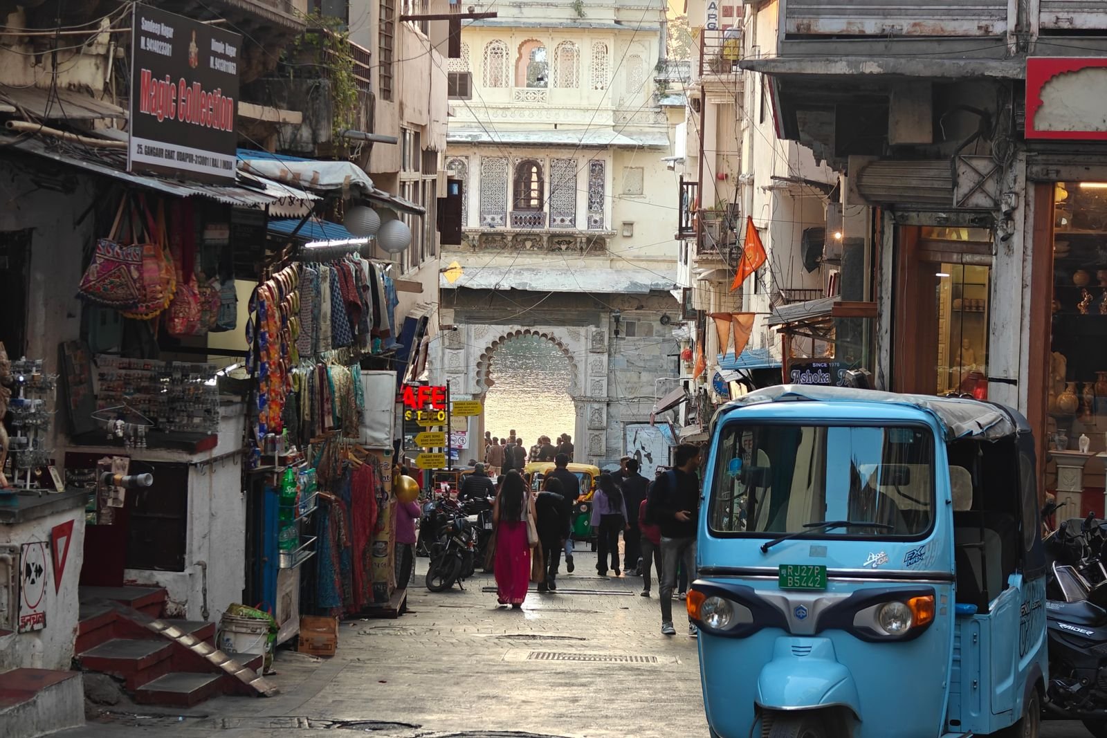 Busy heritage street in Udaipur Old City with a blue tuk-tuk