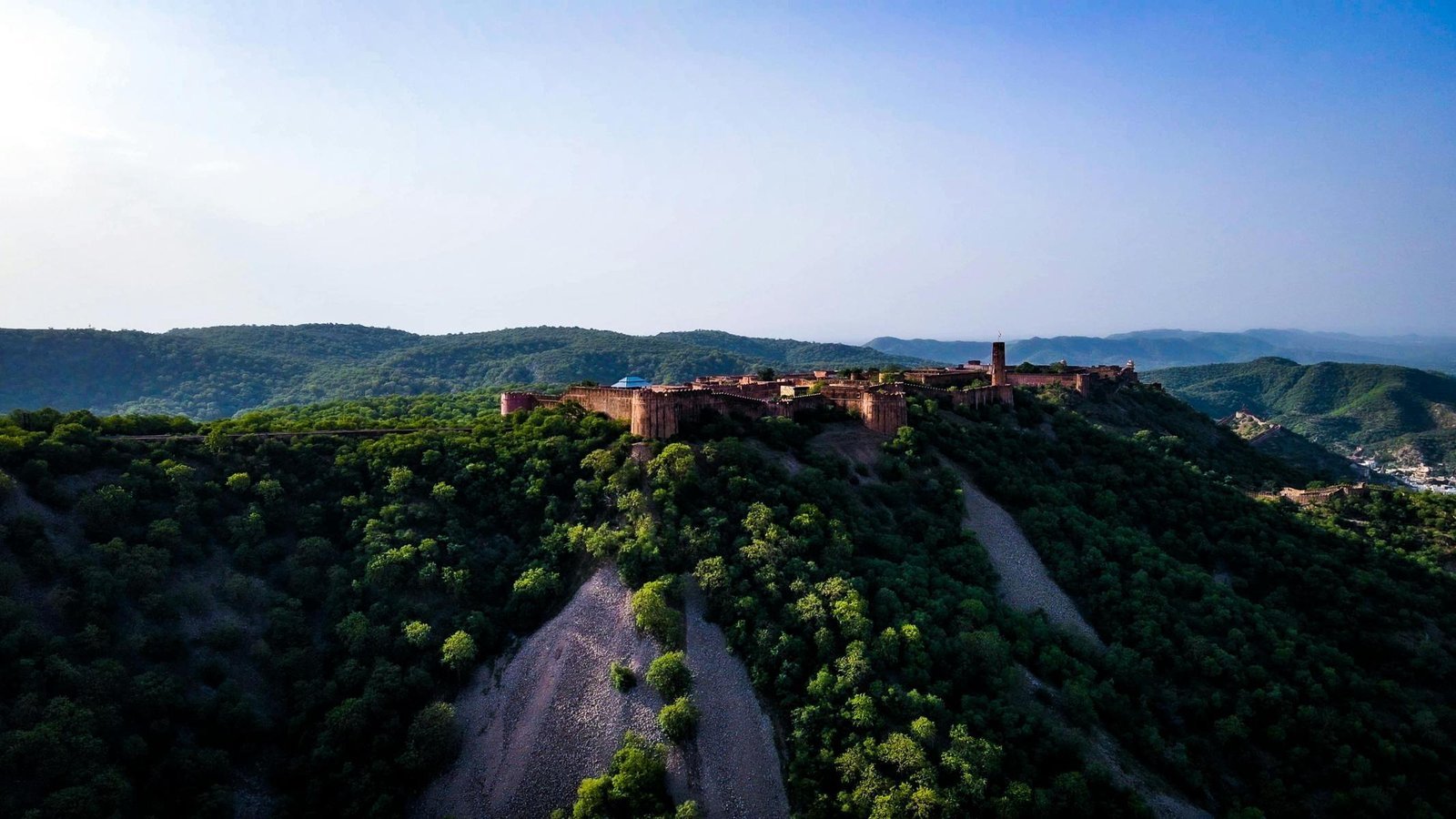 Fort walls stretching across a wooded hilltop near Jaipur