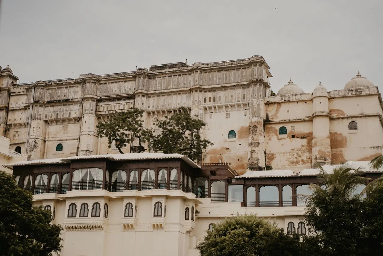 Udaipur City Palace exterior with ornate balconies and trees