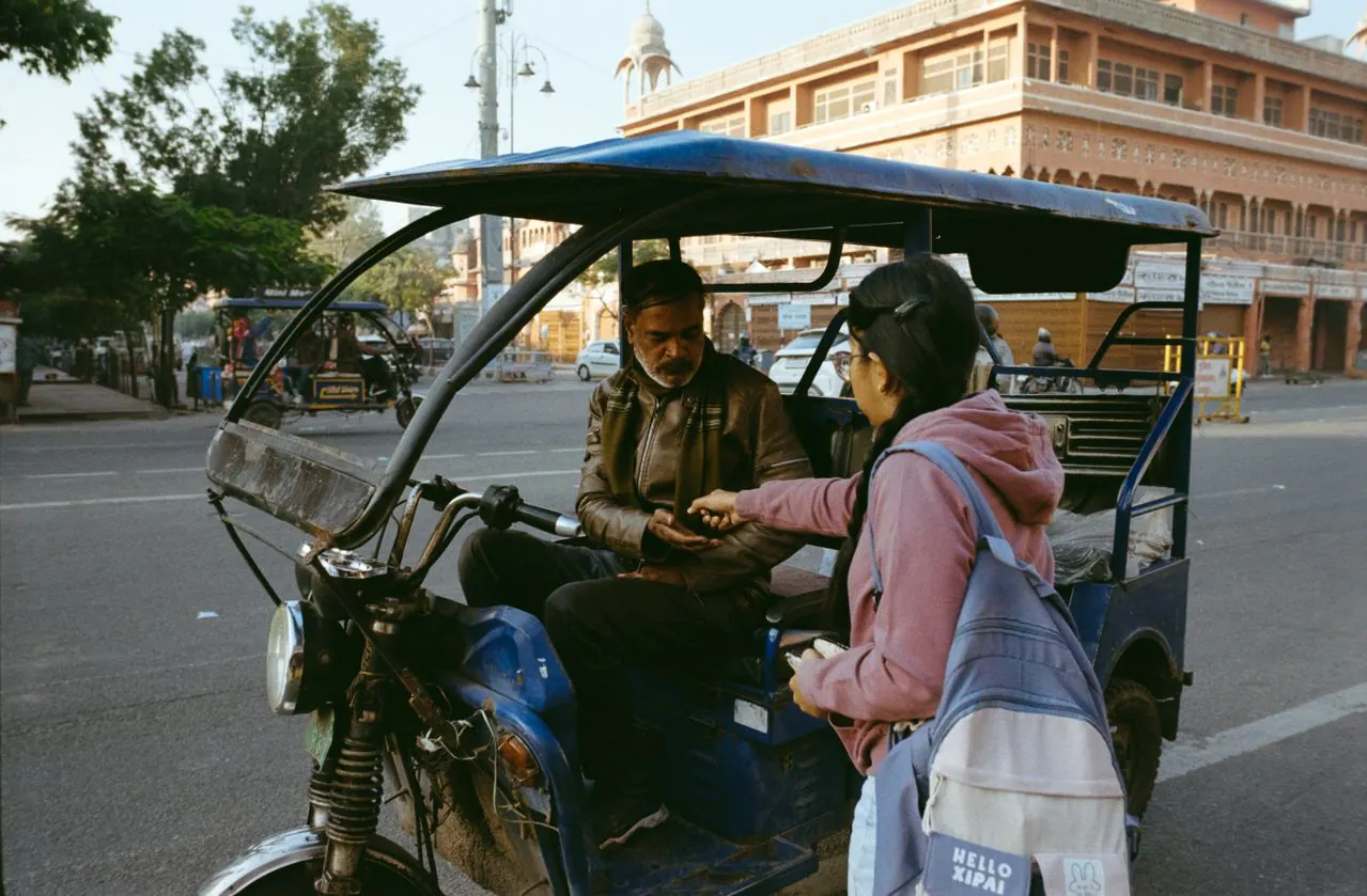 Traveller speaking with a local tuk-tuk driver in Jaipur